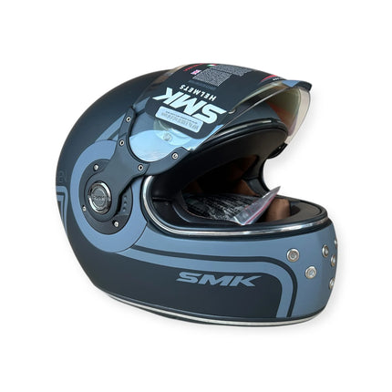 Grey and black SMK full face motorcycle helmet with clear visor and detailed side design
